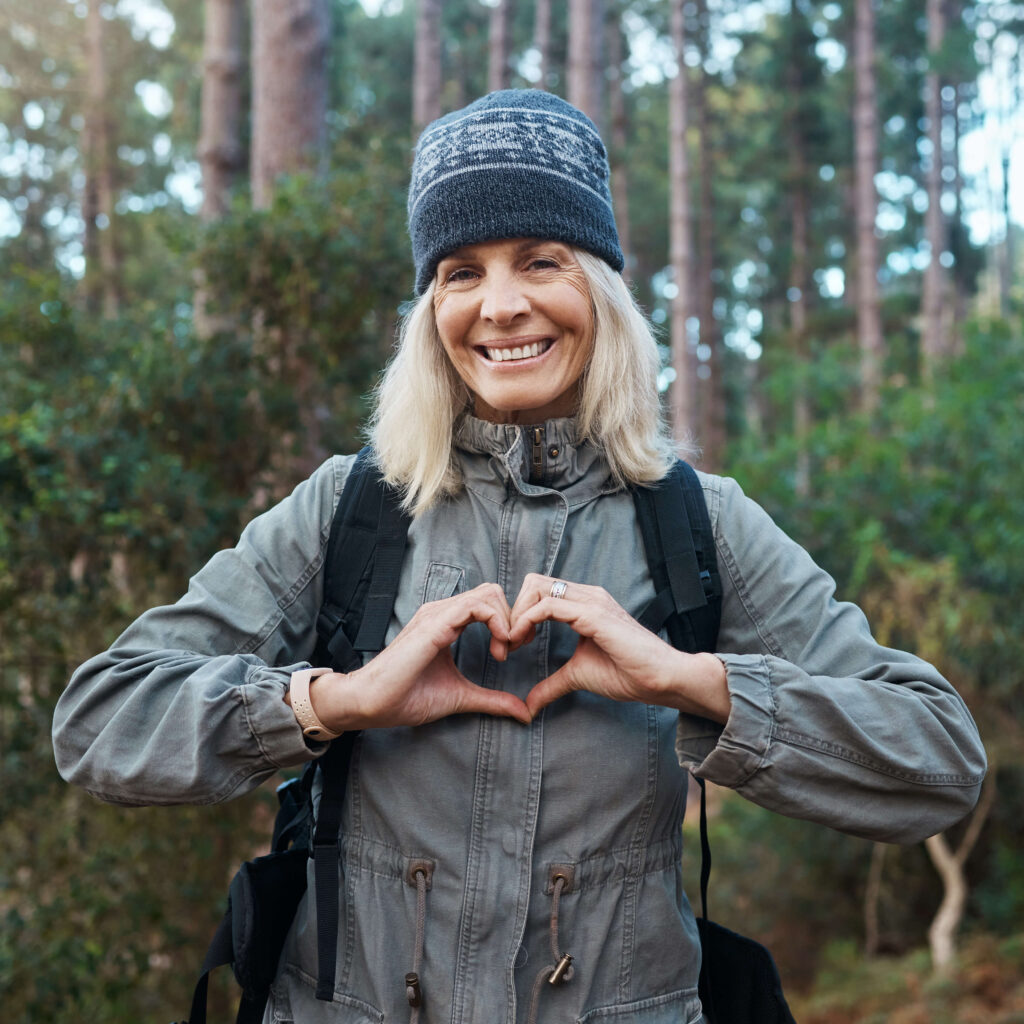 Woman hiking and making heart with hands March 2023
